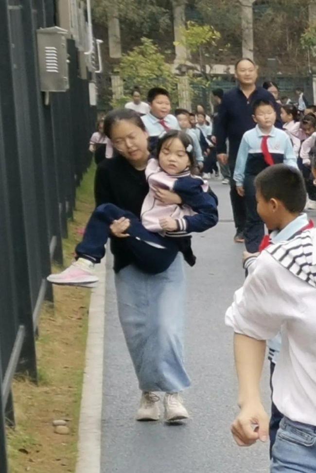 地震中的守护，老师抱起学生迅速撤离的瞬间